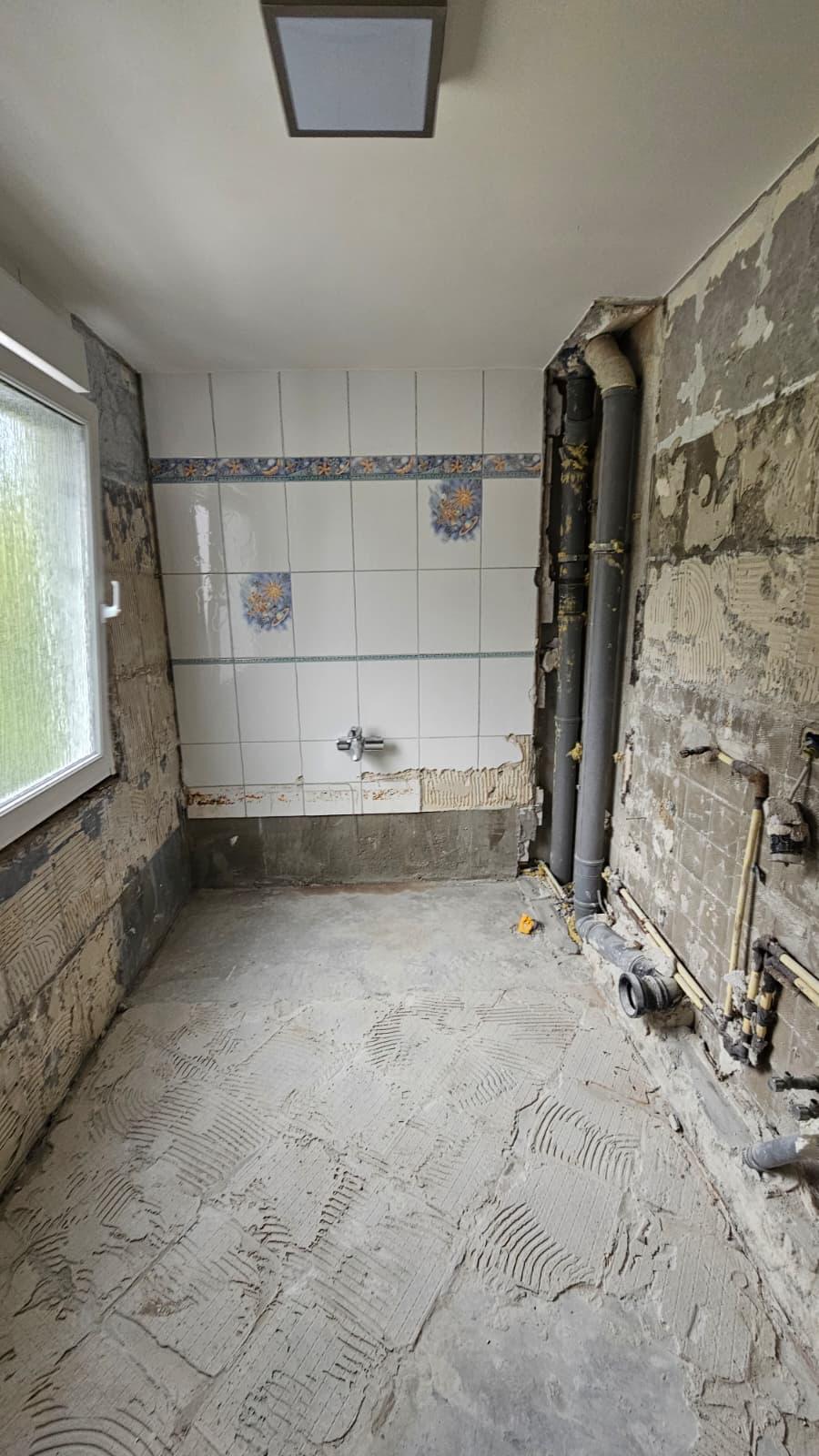 Bad nach dem Ausbau, Wände und Boden frei, Leitungen sichtbar