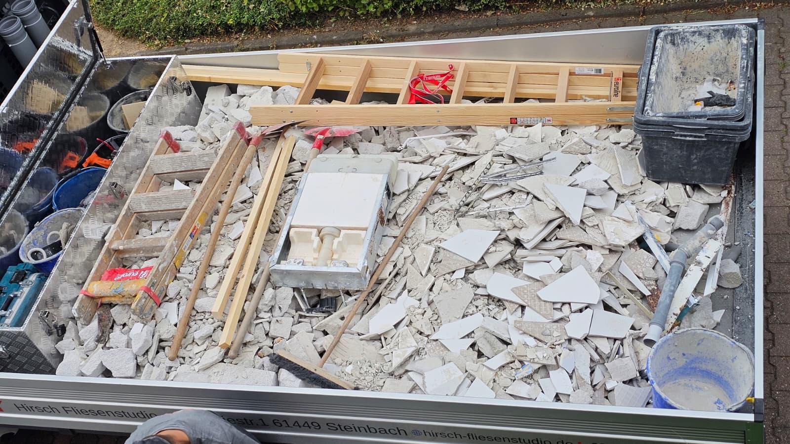Ausgebaute Fliesen, Wanne und Leitungen auf der Ladefläche